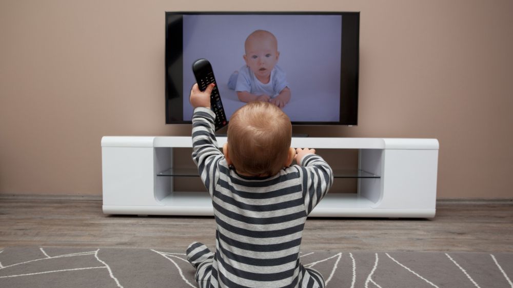 یک کودک چندماهه در حال تماشای تلویزیون