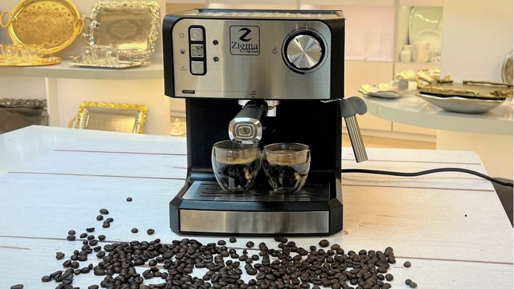 قهوه ساز برند زیگما با دانه‌های قهوه که در جلوی آن پخش شده