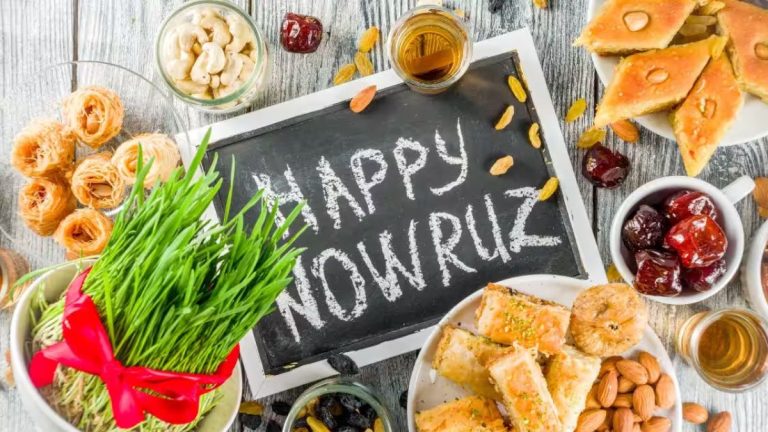 سفره هفت سین که وسط آن یک تخته سیاه وجود دارد که روی آن نوشته happy nowruz