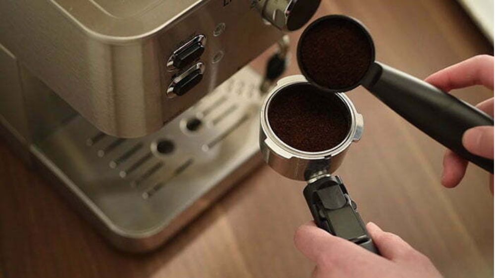 یک نفر در حال تهیه کردن قهوه اسپرسو با دستگاه قهوه ساز برند گوسونیک