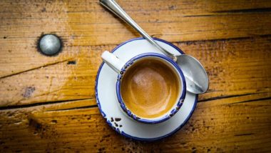 یک فنجان قهوه اسپرسو با کرمای عالی روی یک میز چوبی