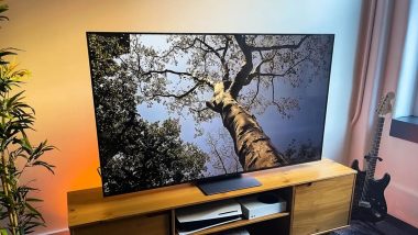 تلویزیون ۵۵ اینچ تی سی ال روی میز چوبی قهوه‌ای