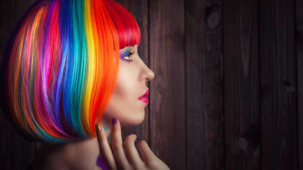 نیم‌رخ یک خانم در حال ژست‌گرفته با موهای رنگین‌کمانی