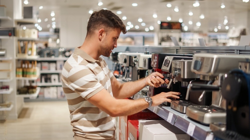 مردی جوان در حال خرید دستگاه اسپرسوساز 