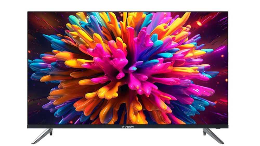 تلویزیون 65 اینچ ایکس ویژن مشکی رنگ که لحظه منفجر شدن رنگ های متنوع را نمایش می‌دهد