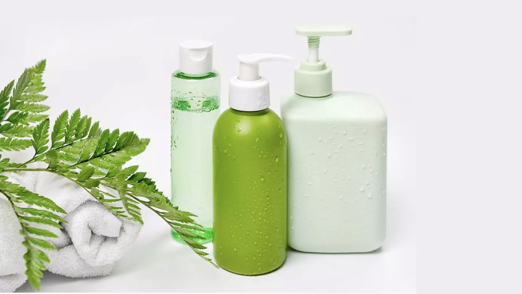 چند محصول مراقبت از پوست در کنار هم و یک حوله و برگ سبز در کنارشان