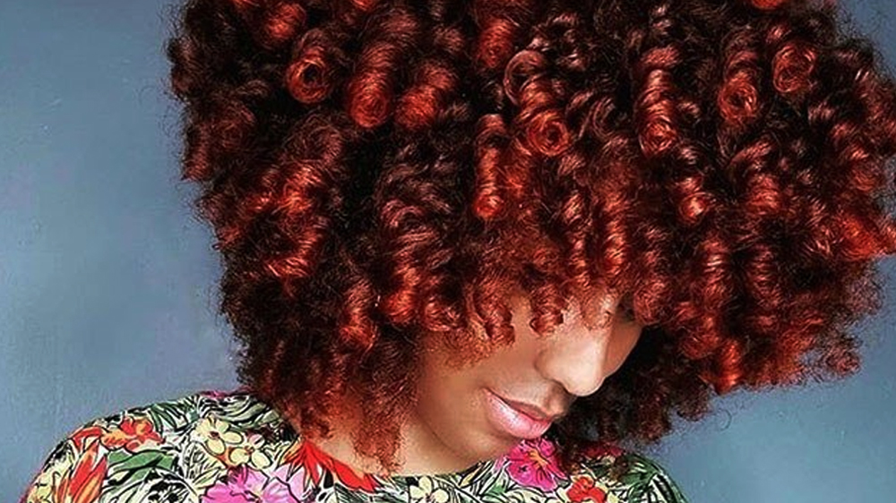 زنی با موهای قرمز فرشده و سر سه رخ رو به پایین