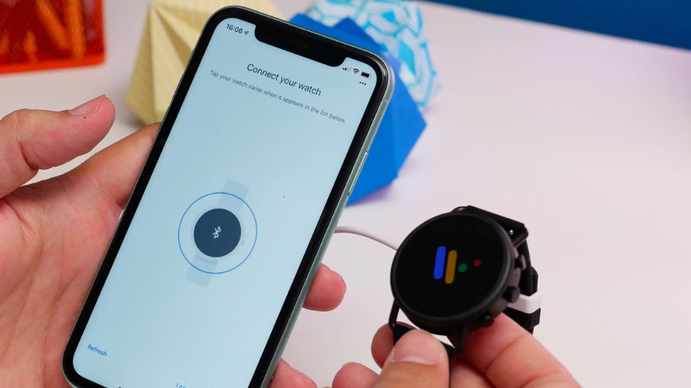 فردی در حال اتصال ساعت هوشمند گوگل به یک گوشی آیفون 
