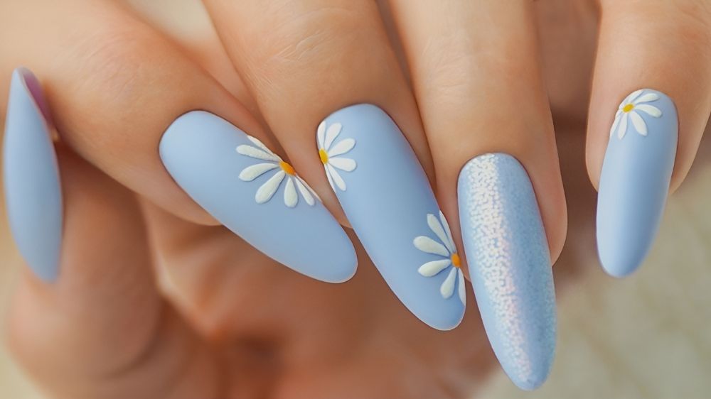 طراحی ناخن با رنگ لاک آبی مات و دیزین گل بابونه