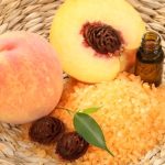 یک سبد حصیری یک هلوی کامل و یک هلوی نصف‌شده که هسته‌اش نمایان است.