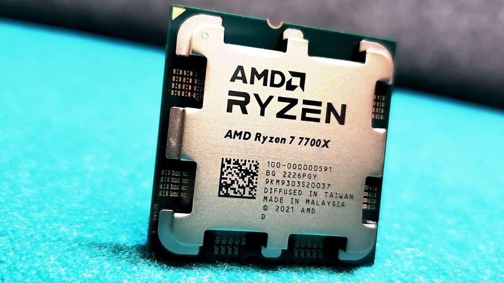 پردازنده ایامدی رایزن 7 7700X با لوگو AMD Ryzen در بالا در حالت ایستاده روی سطح آبی روشن با پس زمینه مات