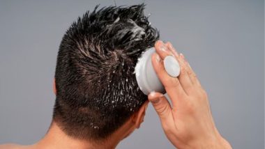 نمای پشت سر مردی که در حال استفاده از اسکراب سر است.