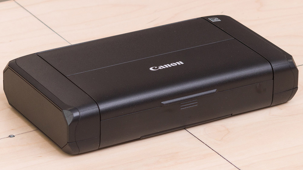 پرینتر کانن PIXMA TR150 بیسیم و قابل حمل به رنگ مشکی روی سطح چوبی