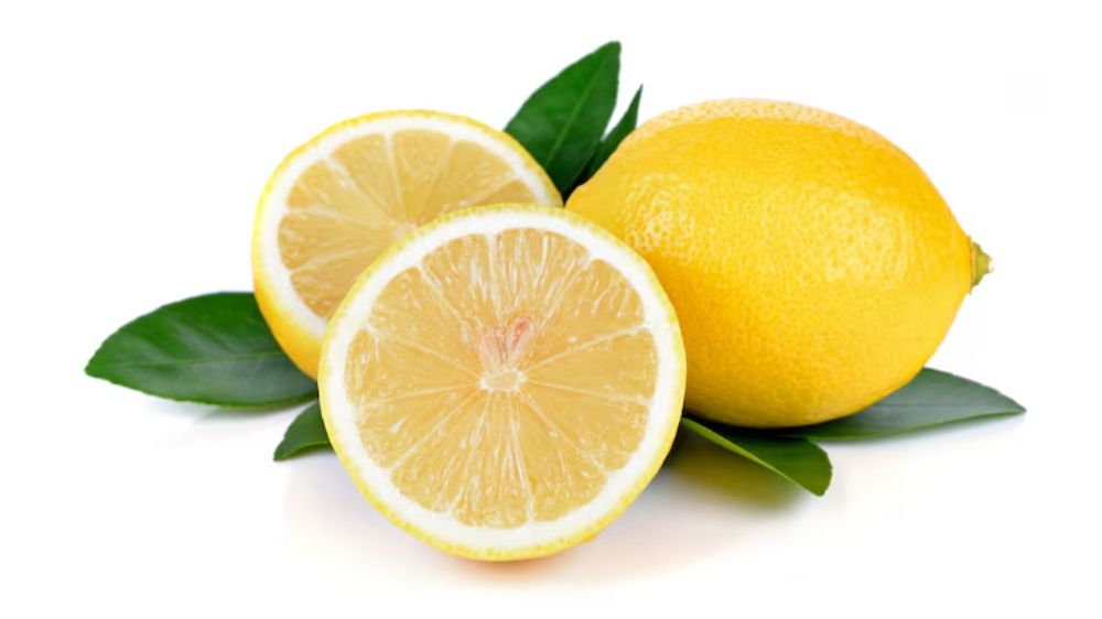 یک عدد لیموی تازه به همراه دو برش لیمو روی سطح صاف قرار گرفته است.