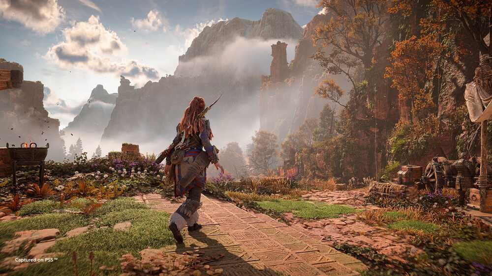 شخصیت ایلوی از بازی horizon forbidden west که در حال قدم زدن در یک کوهستان است