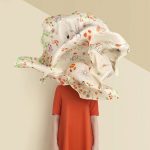خانمی ایستاده با پارچه ای معلق روی صورتش