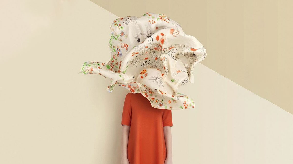 خانمی ایستاده با پارچه ای معلق روی صورتش