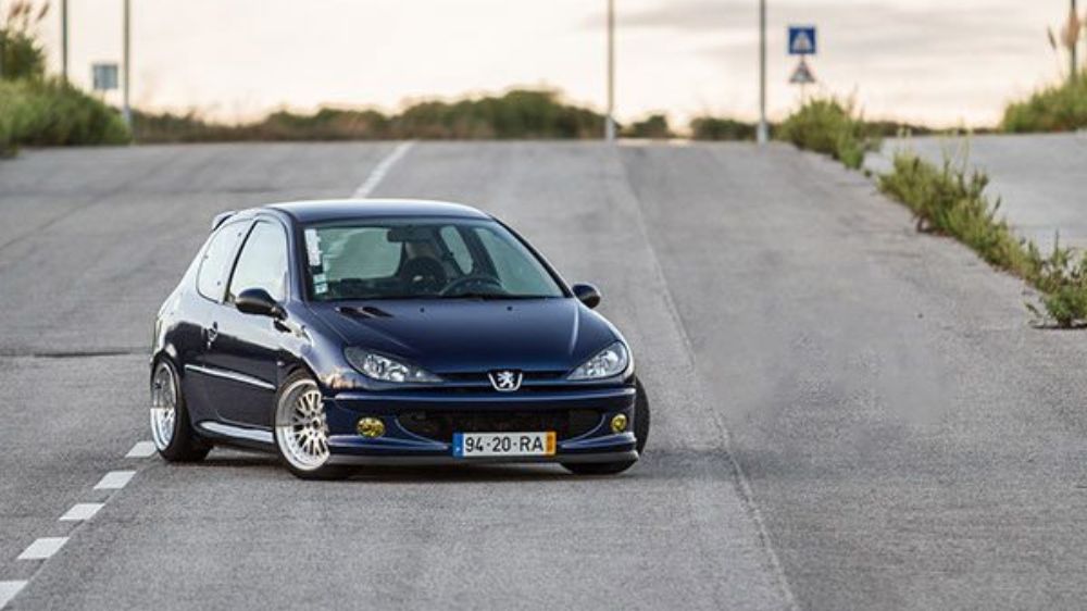 206 تیپ دو اسپرت به رنگ سرمه ای که در یک خیابان به صورت کج پارک شده است