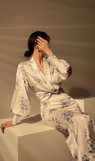 خانمی نشسته با پیراهن سفید با گل های آبی