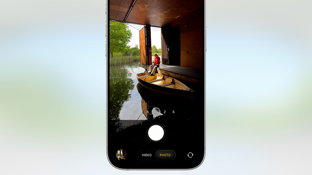 گوشی آیفون در حال نمایش برنامه دوربین بازطراحی شده سیستم عامل iOS 26