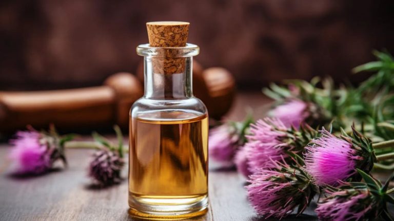 گل خار مریم و یک شیشه روغن گل خار مریم روی میز چوبی