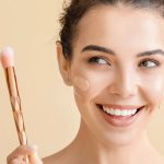 زن در حال کرم پودر زدن با براش کرم پودر