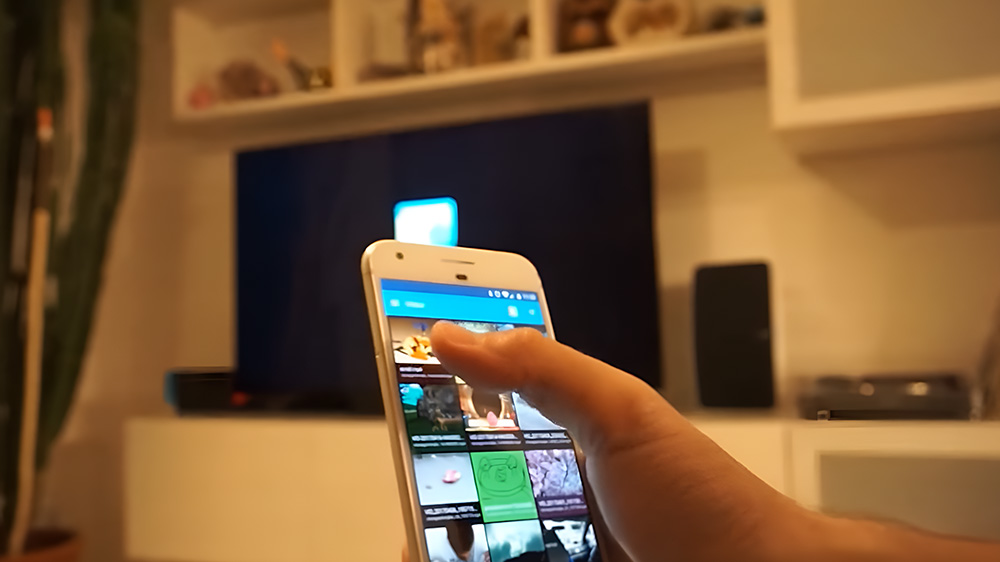 یک نفر در حال وصل کردن گوشی به تلویزیون از طریق برنامه DLNA با نام Local Cast
