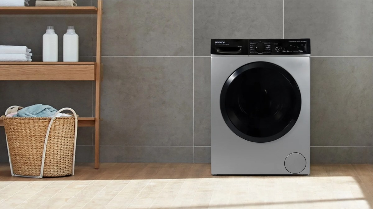 ماشین لباسشویی مدرن دوو در فضایی آرام و مینیمال با دیوار سنگی و کف چوبی