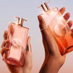 دو دست ظریف زنانه که شیشه‌های عطر نگه داشته‌اند.