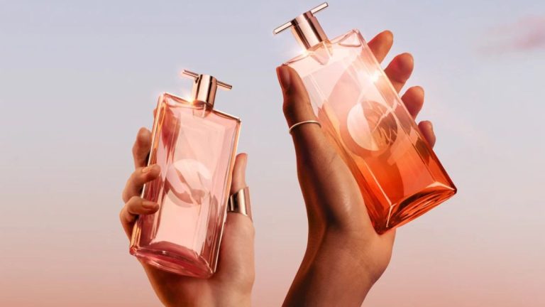 دو دست ظریف زنانه که شیشه‌های عطر نگه داشته‌اند.