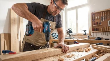 یک نجار در حال استفاده از دریل شارژی بوش در کارگاه