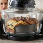 یک خانم در حال نگاه کردن به کیکی که در هواپز خراب شده